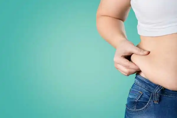 Image of woman pinching her love handles to show weight gain Hatfield
